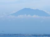Au loin, un avion se pose devant Kuta et le le volcan Agung